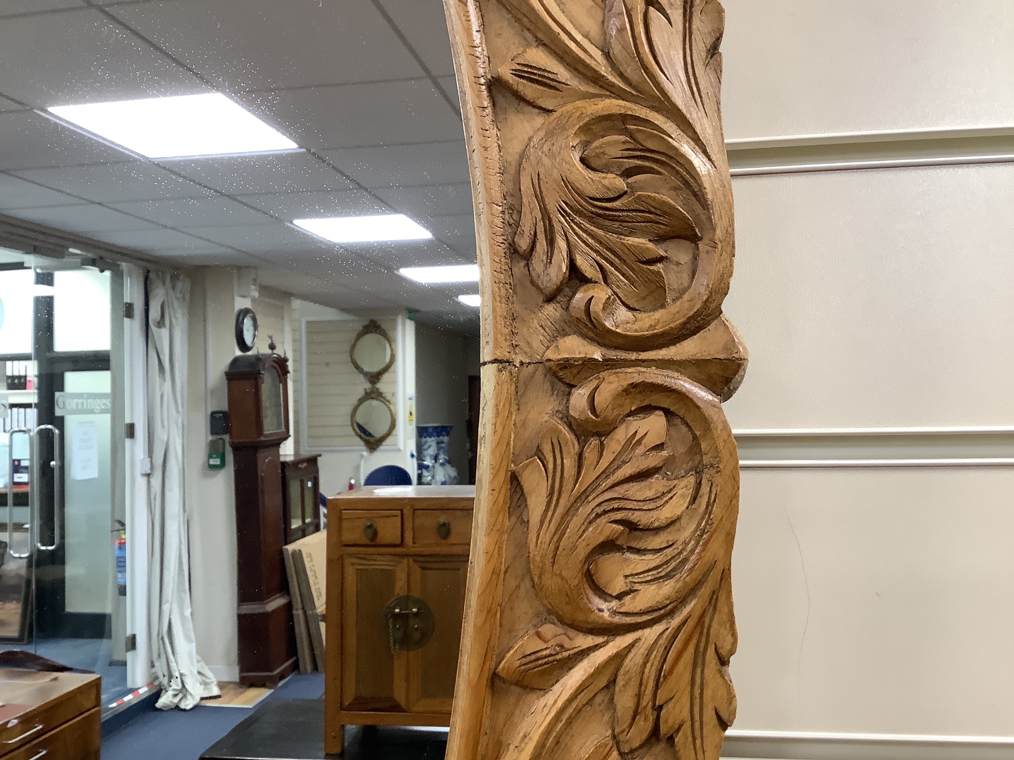 A carved oak oval framed wall mirror, width 70cm, height 109cm